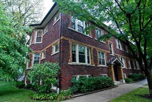 Front view of a two-story brick building with multiple windows.