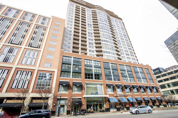 Front view of a multi-story building with commercial spaces on the lower levels and residential units above.