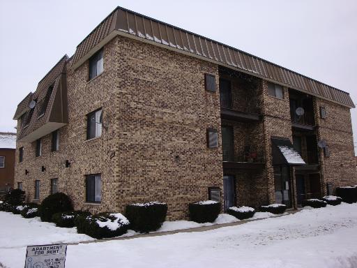 Front view of a multi-story brick apartment building.