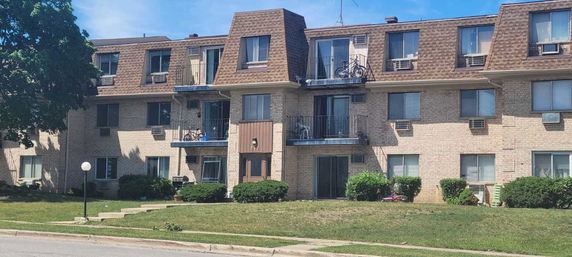 Front view of a multi-story apartment building with balconies.