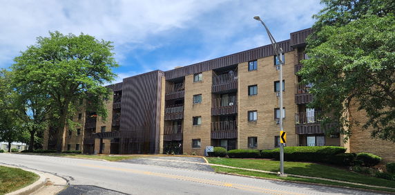Front view of a multi-story apartment building with balconies.