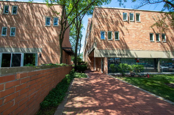 Front view of a brick residential building with multiple windows.