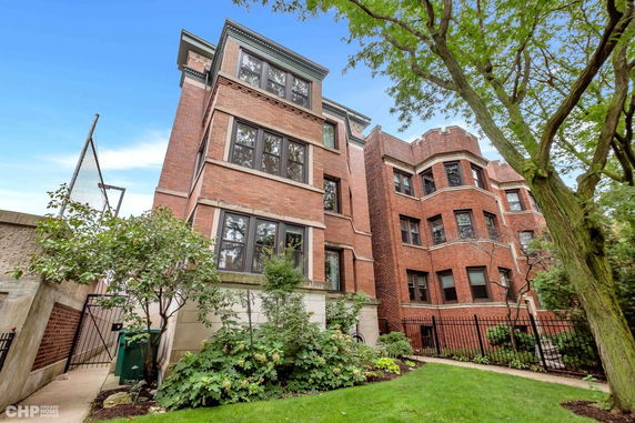 Front view of a multi-story brick building with large windows.