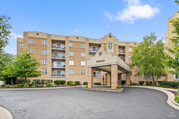 Front view of a multi-story residential building with a covered entrance.