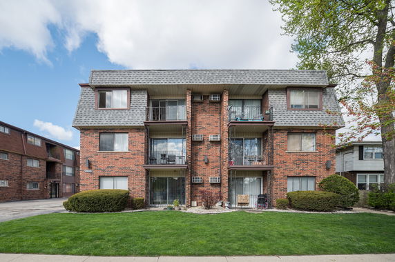 Front view of a three-story brick apartment building.