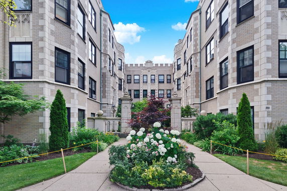 Front view of a multi-story building with a landscaped garden entrance.