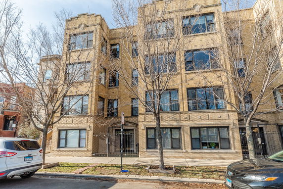 Front view of a multi-story brick building with large windows.