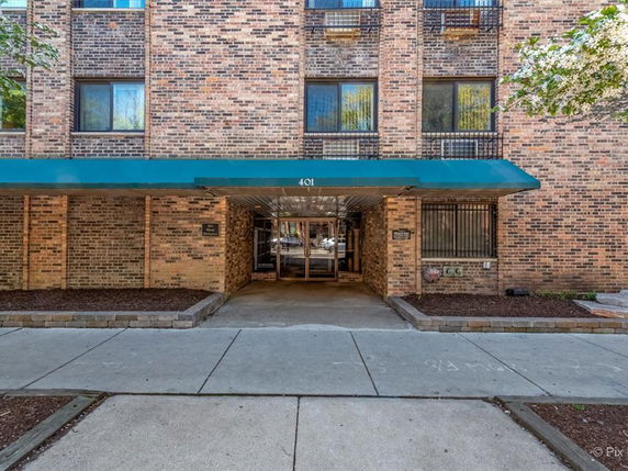Front view of a multi-story brick building with an entrance canopy.
