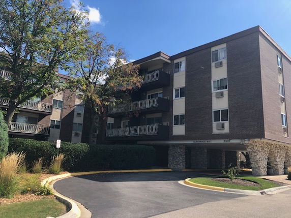 Front view of a multi-story apartment building with balconies.