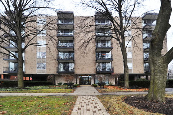 Front view of a multi-story apartment building with balconies.