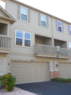 Front view of a multi-story house with balconies and a double garage.