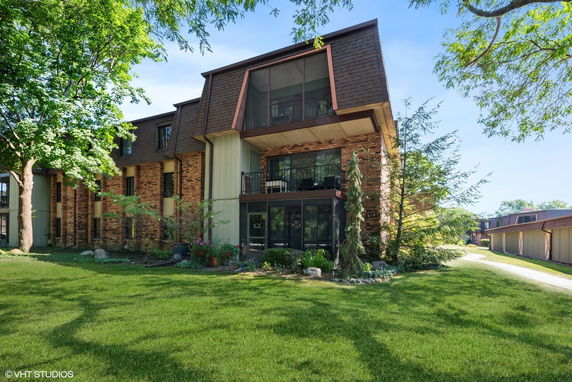 Front view of a multi-story building with a brown roof and brick facade.