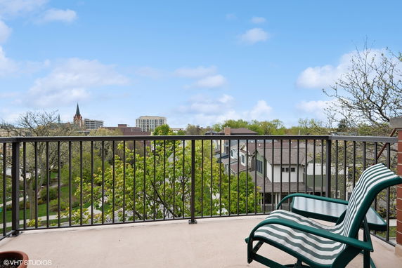 View from a balcony overlooking a residential area and cityscape in the background.