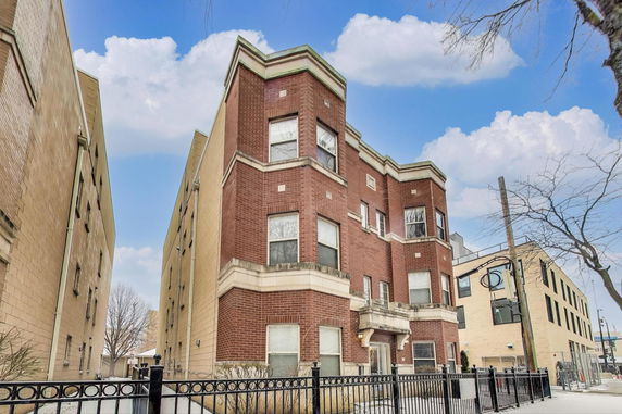Front view of a multi-story brick building with decorative elements.