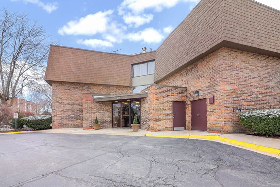Front view of a brick building with large windows and a covered entrance.