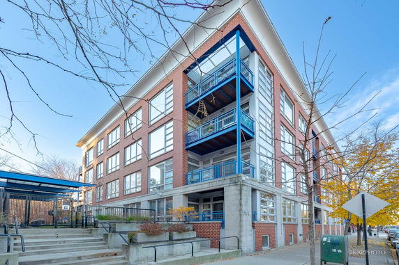 Front view of a multi-story brick building with large windows and balconies.