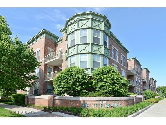 Front view of a multi-story building with brick exterior and decorative green accents.