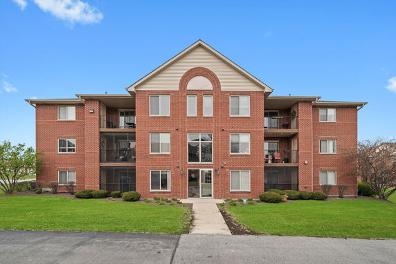 Front view of a multi-story brick apartment building.