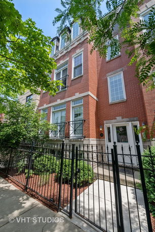 Front view of a three-story brick townhouse.