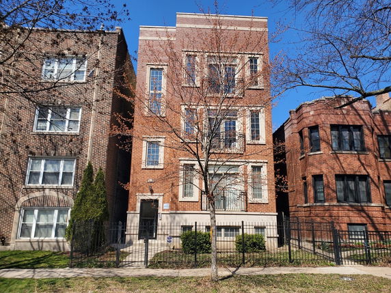 Front view of a multi-story brick apartment building.