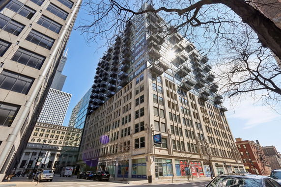 Front view of a multi-story office building with glass windows and balconies.