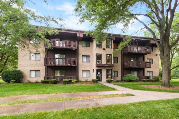 Front view of a multi-story apartment building with balconies.