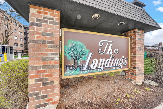 Front view of a building entrance with a sign reading 'The Landings' on a brick structure.