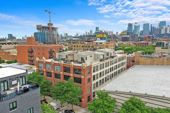 View of a cityscape with various buildings and a construction crane in the background.