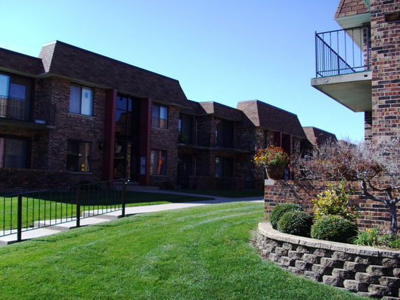 Front view of multiple brick residential buildings with balconies.
