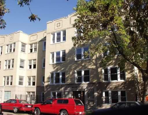 Front view of a four-story apartment building with multiple windows and a simple facade.