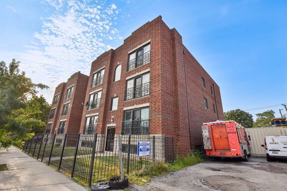 Front view of a multi-story brick apartment building.