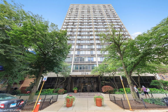 Front view of a high-rise building with multiple windows and an entrance at the base.