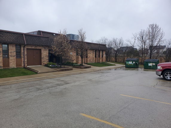 Front view of a single-story brick building with a sloped roof.