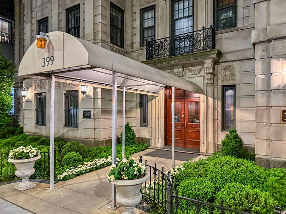 Front view of a building with a covered entrance and decorative facade.