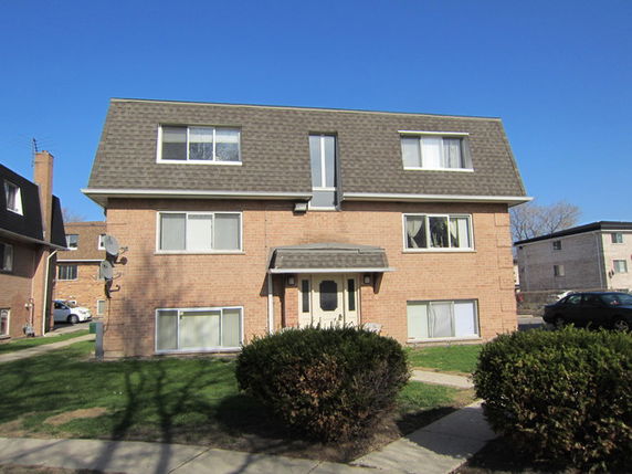 Front view of a two-story apartment building with a sloped roof.