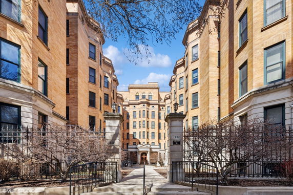 Front view of a multi-story residential building with a central entrance and symmetrical design.