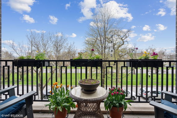 View of surrounding areas from a balcony with potted flowers and outdoor seating.
