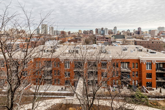 Panoramic view of urban buildings with a prominent red brick structure in the foreground.