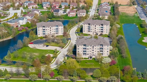 Panoramic view of a residential area with multiple multi-story buildings surrounded by water bodies and greenery.