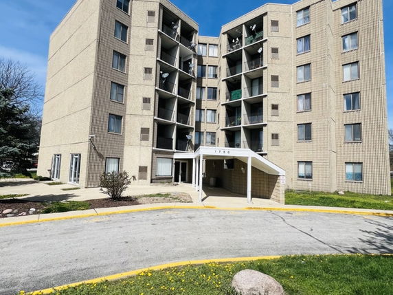 Front view of a multi-story apartment building with balconies.