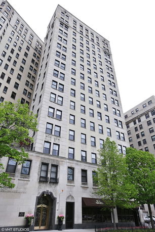 Front view of a tall multi-story building with numerous windows.
