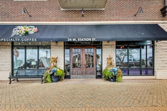 Front view of a coffee shop with brick and stone exterior.