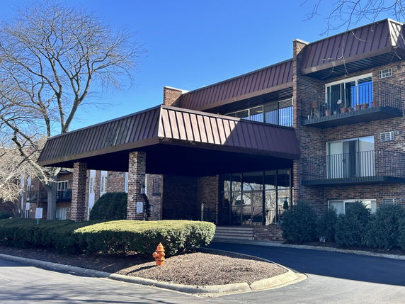 Front view of a multi-story brick building with balconies.