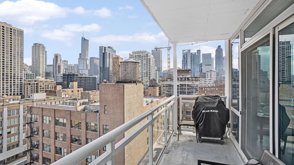 Balcony view overlooking city skyline with tall buildings.