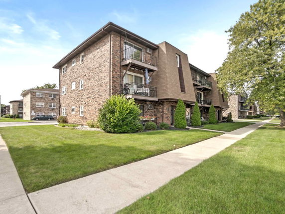 Front view of a three-story apartment building with balconies.