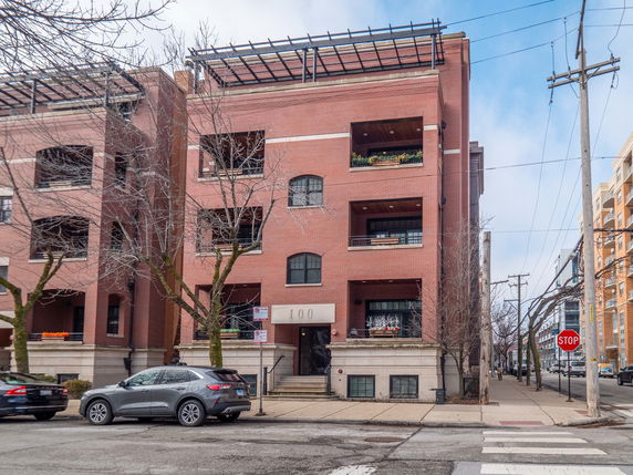 Front view of a multi-story brick building with balconies.