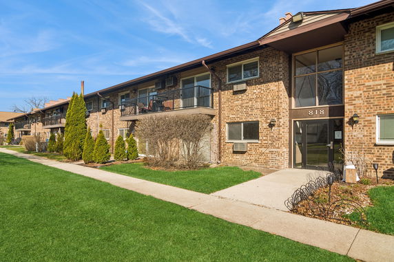 Front view of a two-story brick apartment building with balconies.