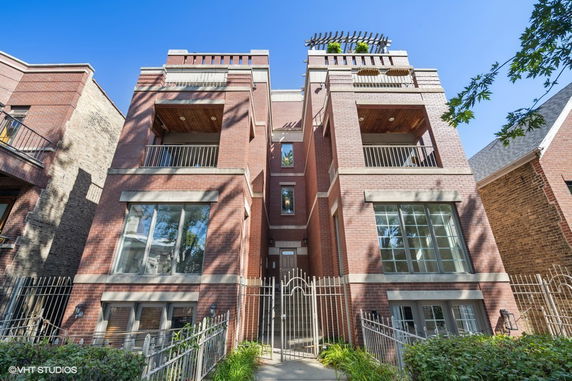 Front view of a multi-story brick building with balconies.