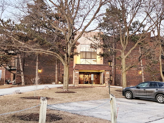 Front view of a multi-story brick building with a central entrance.