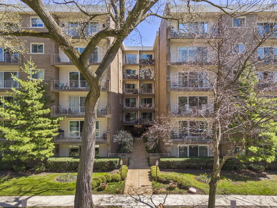Front view of a multi-story apartment building with balconies.